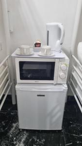 a white microwave sitting on top of a white refrigerator at Pension Susita in Alicante