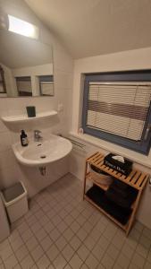 a white bathroom with a sink and a mirror at Gemütliche 1-Zimmer-Wohnung im Hildesheimer Wald in Diekholzen +11 photos
