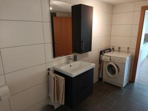 a bathroom with a sink and a washing machine at Gästehaus Michael in Navis