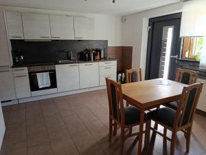 a kitchen with a wooden table and a table and chairs at Gästehaus Michael in Navis