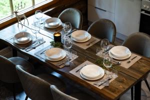 a wooden table with plates and wine glasses on it at Villa RukanKelo in Ruka +19 photos