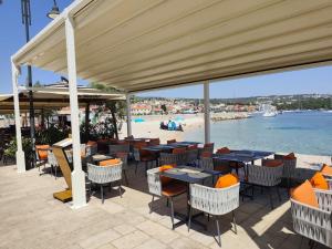 a restaurant with tables and chairs and a beach at Apartment Karmela in Primošten