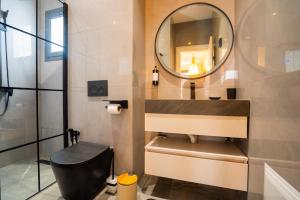 a bathroom with a toilet and a mirror at Résidence LOBOS by Ilios in Dakar +288 photos