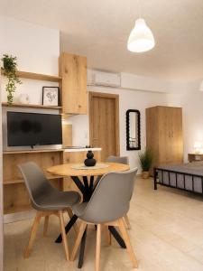 a living room with a table and chairs and a television at Musses apartment 1 Modern Studio with Free Parking in Limín Khersonísou