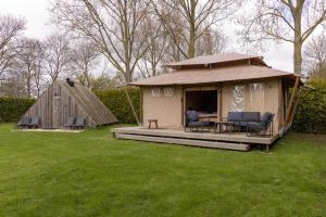a yurt with a table and chairs in a yard at Safari Lodge at Back to Basic in Zwaanshoek +23 photos