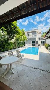 a house with a pool and a table and chairs at Pousada do Tio Cido in Guarujá
