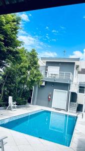 a house with a swimming pool in front of a house at Pousada do Tio Cido in Guarujá