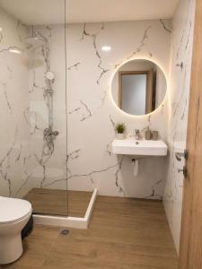a bathroom with a toilet and a sink and a mirror at Musses apartment 1 Modern Studio with Free Parking in Limín Khersonísou +9 photos