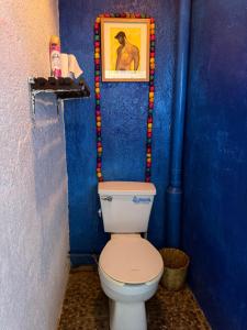 a bathroom with a toilet in a blue wall at La Máxima Drag Show & Bar LGBT in Zipolite +88 photos