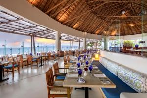 a restaurant with tables and chairs and a bar at Grand Velas Riviera Nayarit-All Inclusive in Nuevo Vallarta