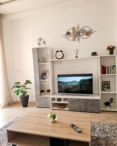 a living room with a tv and a table at Asilah Cozy Pieds dans l'eau in Asilah