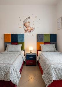 a bedroom with two beds with a baby on the moon at Asilah Cozy Pieds dans l'eau in Asilah +34 photos
