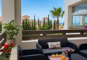 a patio with chairs and a table and a view of the ocean at Asilah Cozy Pieds dans l'eau in Asilah