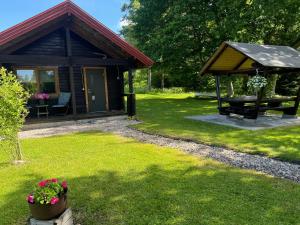 a cabin with a picnic table and a bench in a yard at Laasi Cozy Cottage in Kaigutsi