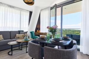 a living room with a table and chairs and a couch at WAVE Resort & Spa in Międzyzdroje