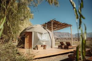 a yurt with chairs and a wooden deck at Domos Uspallata in Uspallata