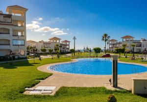 a swimming pool in a park next to a building at Asilah Cozy Pieds dans l'eau in Asilah