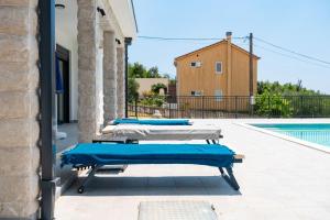 a row of lounge chairs sitting next to a swimming pool at Villa Montenegrina in Krapina