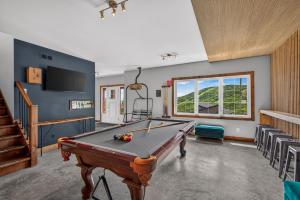 a living room with a pool table and a staircase at Le Sto Shack 25 Chemin Blanc by Les Chalets Alpins in Stoneham