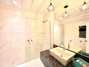 a bathroom with a sink and a shower at Royal Turquesa Boutique Hotel in Búzios