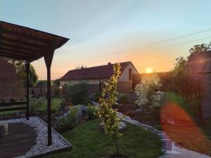 a garden at sunset with a tree in the yard at Chalupa Kdovíkde in Budyně nad Ohří