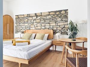 a bedroom with a bed and a stone wall at Vita Serena in Gyenesdiás +49 photos