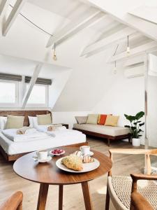 a living room with two beds and a table at Vita Serena in Gyenesdiás