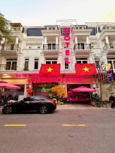 a car parked in front of a building with two flags at L'amour Hotel in Ho Chi Minh City