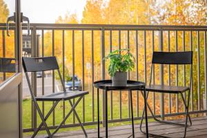 two chairs and a table with a potted plant on a balcony at First Hotel Uppsala East in Uppsala