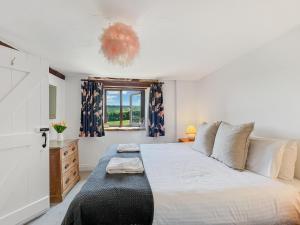 a bedroom with a large bed and a window at Jasper Cottage Hawkridge in Dulverton