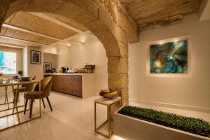 a living room with a table and a painting on the wall at 23 Boutique Hotel in Il-Furjana