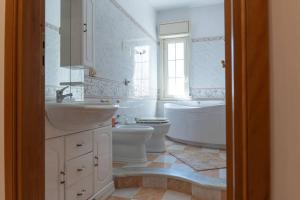 a bathroom with two sinks and a tub and toilet at Casa Vacanza Colletta - appartamenti e lido in Casteldaccia +69 photos