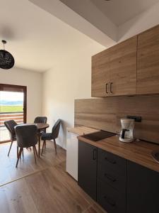 a kitchen with wooden cabinets and a table with chairs at Tri ville in Žabljak