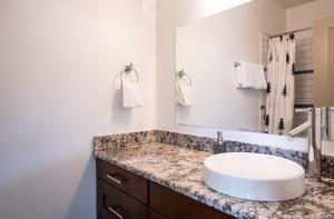 a bathroom with a sink and a mirror at Selkirk Snug by Revelstoke Vacations in Revelstoke +17 photos