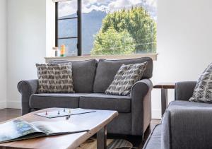 a living room with a couch and a table at Selkirk Snug by Revelstoke Vacations in Revelstoke