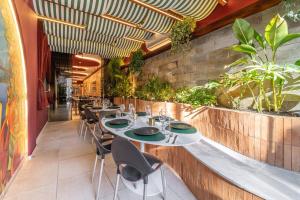 a restaurant with a long table with chairs and plants at AFS LOFT HOSTEL Aracaju in Aracaju