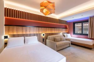 a bedroom with a bed and a couch and a window at ZOI Girni - Seaside Hotel in Olympic Beach