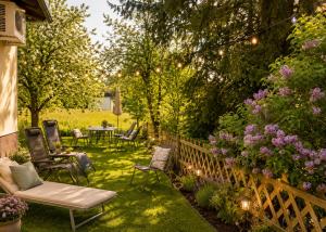 a garden with chairs and tables and flowers at Ferienwohnung Attersee in Steinbach am Attersee