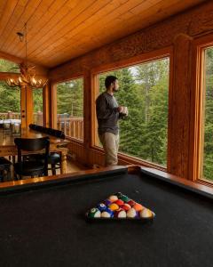 a man standing in front of a pool table at Blue Moose Private pool spa sauna lake access in Wentworth