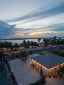a building on the beach with palm trees and the ocean at Maako Retreats in Milandu