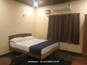 a small bedroom with a bed and a window at Vybhav Residency AC in Anantapur