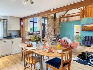 a kitchen and living room with a table and chairs at Kiri Cottage Hawkridge in Dulverton
