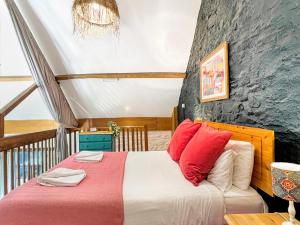 a bedroom with a bed with red pillows at Kiri Cottage Hawkridge in Dulverton