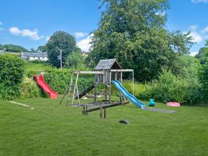a playground with two slides and a swing set at Kiri Cottage Hawkridge in Dulverton
