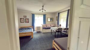 a bedroom with a bed and a table and a bed and a room at Agroturystyka całoroczna Ranczo Husinka in Husinka