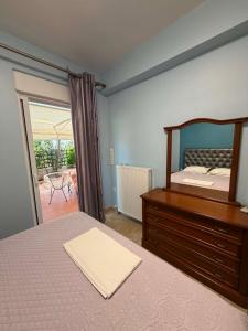 ein Schlafzimmer mit einem Bett und einer Kommode mit Spiegel in der Unterkunft Emily's House in Xylokastro