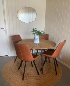 a wooden table with chairs and a vase with a plant at Bird Nest in Bømlo +34 photos