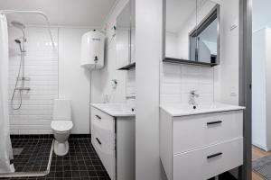 a white bathroom with a sink and a toilet at First Hotel Jönköping North in Jönköping +26 photos