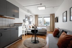 a kitchen and a living room with a table in a room at First Hotel Jönköping North in Jönköping