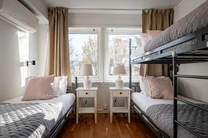 two bunk beds in a room with two windows at First Hotel Jönköping North in Jönköping